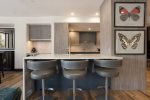 Bright and modern kitchen featuring three stylish barstools, perfect for casual dining and entertaining.